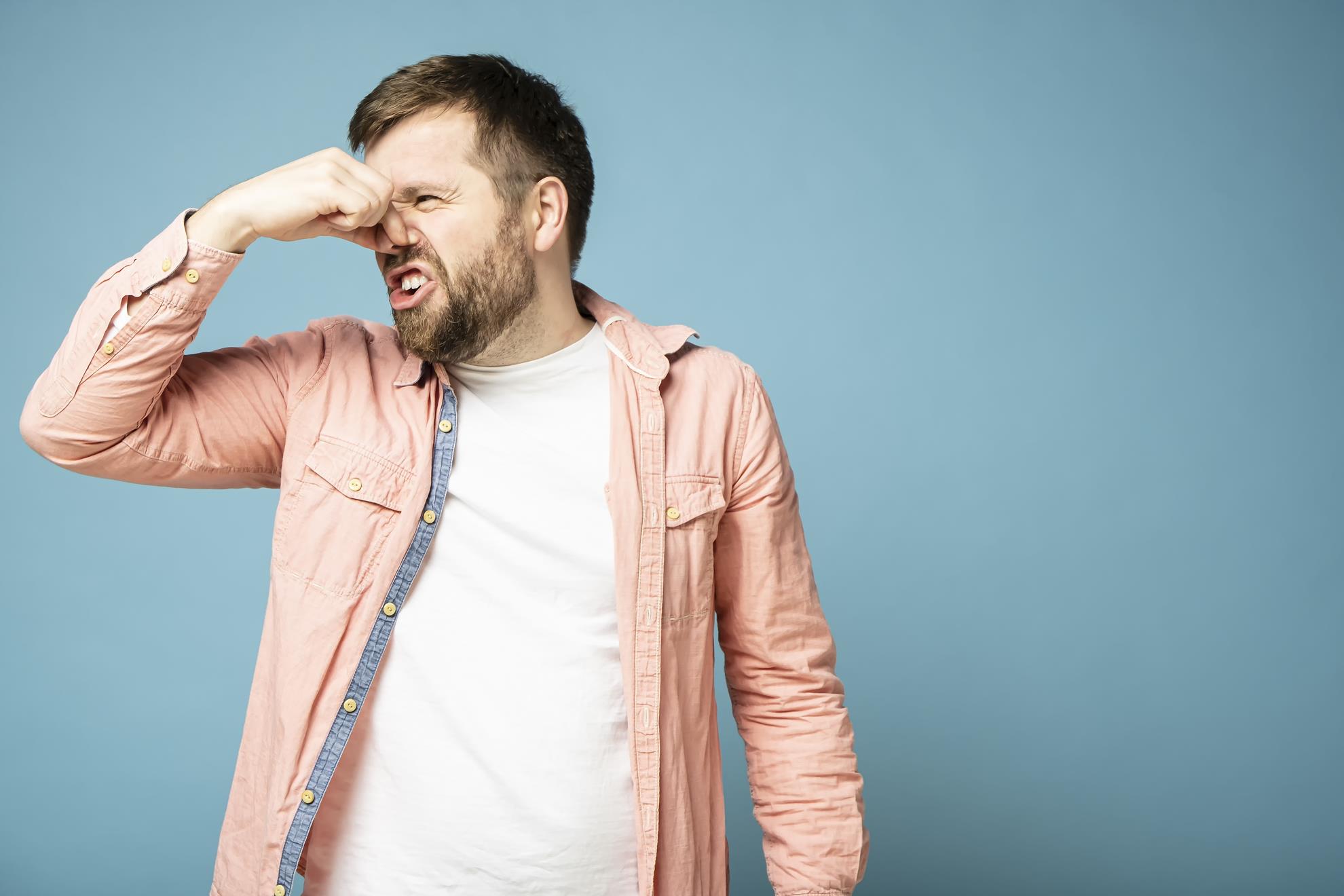 homem com a mão no nariz, dicas de como eliminar gases