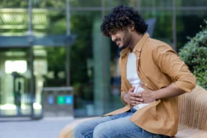 Homem com dor no lado direito da barriga