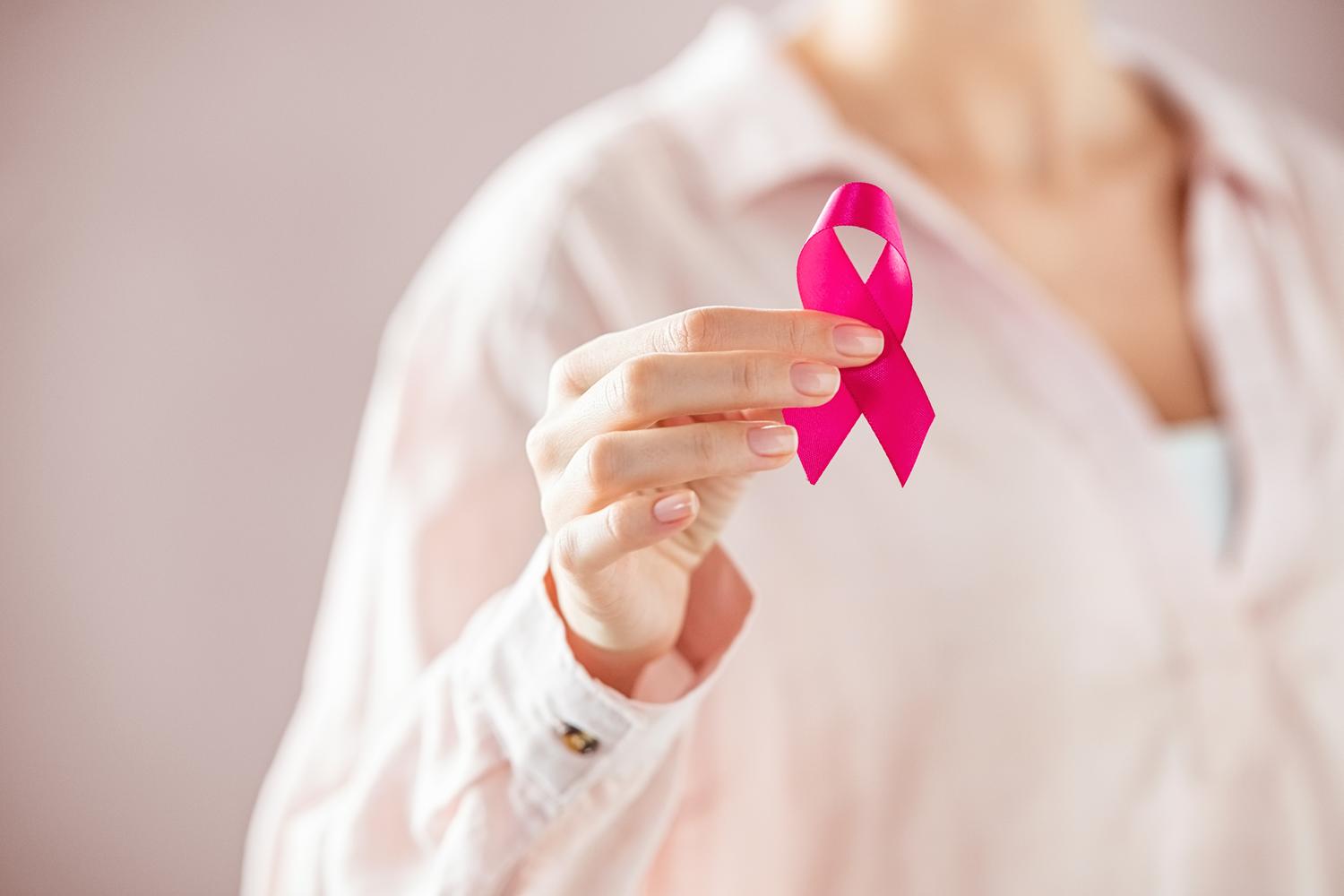 Person holding pink awareness ribbon