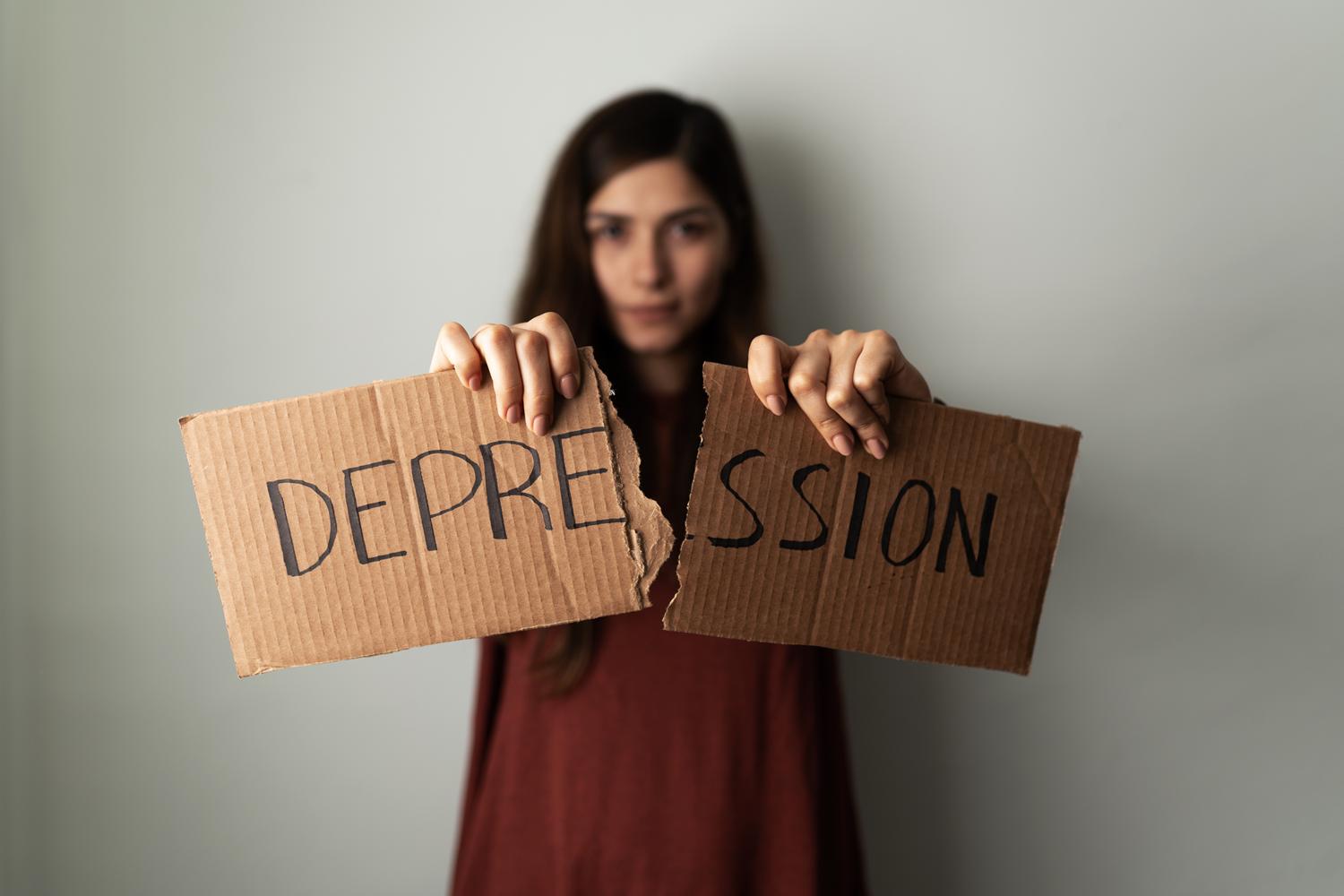 Person tearing cardboard with 'DEPRESSION'