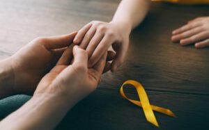 Hands holding with yellow ribbon nearby